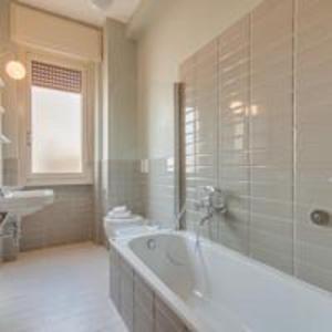 un bagno bianco con vasca e lavandino di Apartments Florence- Palazzo Pitti a Firenze