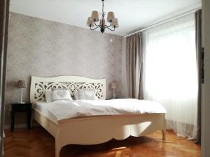 シビウにあるCasa Gloria Sibiuのベッドルーム(白いベッド1台、窓付)
