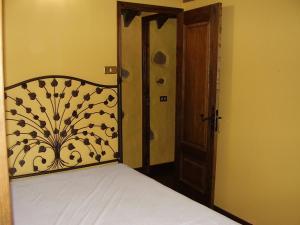 a bedroom with a bed and a wooden door at Casa Rural Poblado Jirdana in La Torre