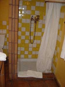 a bathroom with a shower with a tub and a toilet at Casa Rural Poblado Jirdana in La Torre