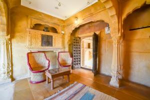 sala de estar con 2 sillas y mesa en Hotel Suraj, en Jaisalmer
