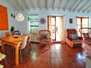a living room with a wooden table and chairs at Casa Jazmin Carabeo in Nerja
