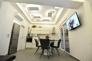 Un comedor con una mesa y un televisor en la pared. en Villa Benelux, en Zadar