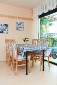 una sala da pranzo con tavolo con 4 sedie e tavolo di Ferienhaus Duenenrose a Bensersiel