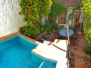 een zwembad met een tafel en stoelen en een patio bij Casa Jazmin Carabeo in Nerja