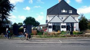 two people riding bikes in front of a house at Hotel-Restaurant Lann Roz / Côte Cuisine in Carnac