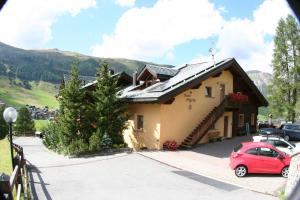 a house with a car parked in a parking lot at Chalet Freita in Livigno