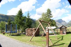 un parque con un parque infantil con montañas al fondo en Chalet Freita, en Livigno 9 fotos más