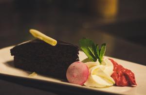 een stuk chocoladetaart en aardbeien op een bord bij Hotel Brasserie de Kroon in Gulpen