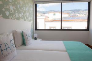 sypialnia z łóżkiem i dużym oknem w obiekcie Five Design Rooftop by Storytellers w Funchal
