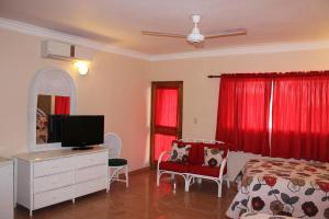 a bedroom with a bed and a flat screen tv at Hotel Bayahibe in Bayahibe