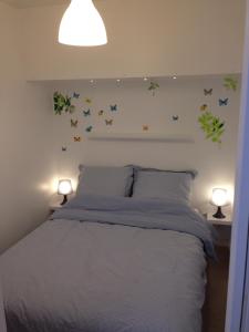 ein Schlafzimmer mit einem Bett mit blauen Schmetterlingen an der Wand in der Unterkunft Place aux Oignons Vieux Lille 4 personnes in Lille