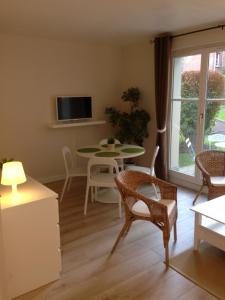 ein Wohnzimmer mit einem Tisch und Stühlen in der Unterkunft Place aux Oignons Vieux Lille 4 personnes in Lille