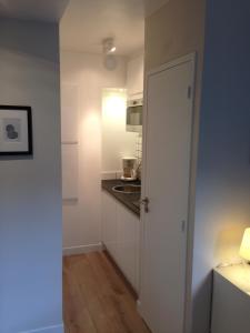 a kitchen with a white door and a sink at Place aux Oignons Vieux Lille 4 personnes in Lille