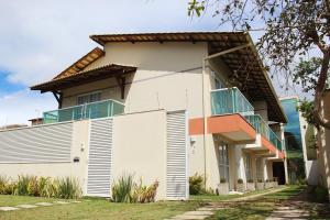 a white house with a balcony at Solar de Manguinhos Flat in Manguinhos