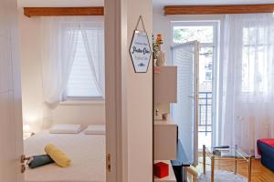 um pequeno quarto com uma cama e uma janela em Linden flower Apartment em Subotica