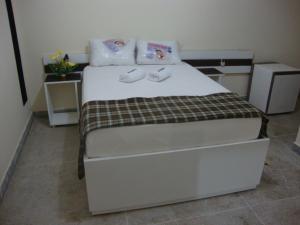 特里温福Hotel Portal Triunfo的一间卧室，床上有两条毛巾
