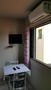 a table and chair in a room with a window at Quarto particular em Vitória in Vitória
