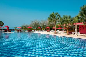 una piscina en un complejo con sombrillas rojas en Decameron Barú - All Inclusive en Playa Blanca