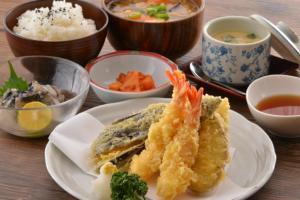 a table with a plate of food and bowls of soup at Value the Hotel Ishinomaki in Ishinomaki