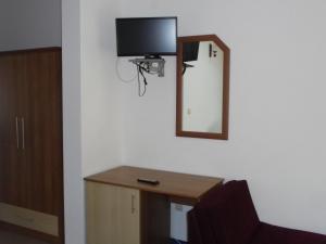 a room with a mirror and a desk with a tv on the wall at Byala Perla Family Hotel in Byala