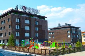 un parque infantil frente a un edificio de ladrillo en Lucky Bansko Aparthotel SPA & Relax en Bansko