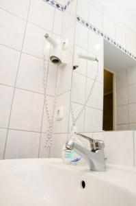 a white sink sitting under a shower next to a toilet at Hotel Astrid am Kurfürstendamm in Berlin