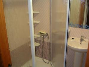 a shower with a glass door next to a sink at Apartamento Jardin II in Gandía