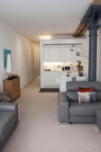 a living room with a couch and a kitchen at Mayflower Apartments, Royal William Yard in Plymouth