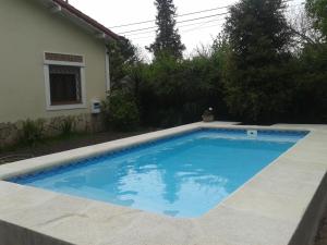 a swimming pool in front of a house at Casa Suiza in Luis Guillón