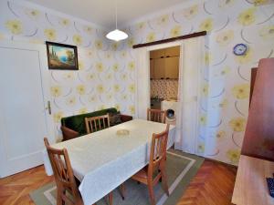 a dining room with a white table and chairs at Guest house Ribaric in Rab