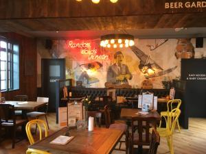 a restaurant with tables and chairs and a large mural at Queen Street Tap in Deal