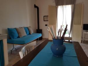 a living room with a table with a blue vase on it at Casa Vacanza Vendicari in Noto Marina