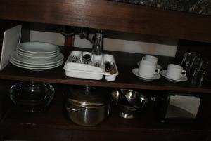 埃尔卡拉法特Departamentos-Cabañas y Habitaciones Compartidas El Puente的厨房架子上放着水槽、盘子和杯子。 更多23张照片