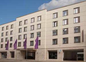 um edifício com bandeiras roxas à sua frente em Mercure Hotel Wiesbaden City em Wiesbaden