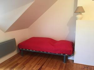 Bett in einem Zimmer mit einer roten Decke in der Unterkunft Maison la Quentinière in Saint-Calais-du-Désert