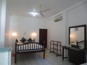 a bedroom with two beds and a mirror and a ceiling at Jungle Holiday Home in Hikkaduwa