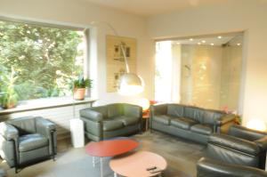 a waiting room with leather furniture and a window at Hotel Eden in Orbassano