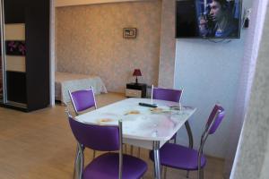 アドレルにあるApartment on Yuzhnykh Kultur 10Aのダイニングルーム(テーブル、紫の椅子付)