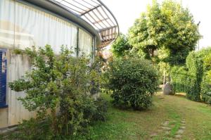 a garden with two trees next to a building at Hotel Eden in Orbassano