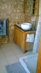 een badkamer met een wastafel en een glazen douche bij La Maison de l'Aubépin in Saint-Savinien