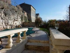 Blick auf einen Swimmingpool mit einem Weinglas in der Unterkunft La Maison de l'Aubépin in Saint-Savinien