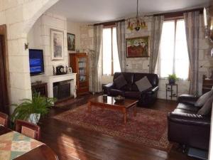 ein Wohnzimmer mit Sofa und Tisch in der Unterkunft La Maison de l'Aubépin in Saint-Savinien