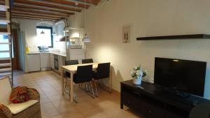 a living room with a dining table and a kitchen at Cal Ton in Castelltersol
