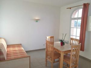 a dining room with a table and chairs and a window at Résidence de L'Océan in La Tranche-sur-Mer