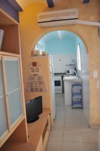 a kitchen with an archway and a kitchen with a refrigerator at Casa a 50 metros del Mar in Oliva
