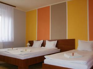 2 camas en una habitación con paredes de color naranja y amarillo en Warneńczyka 85A bezpłatny parking, faktura, prywatna łazienka, klimatyzacja, en Rzeszów