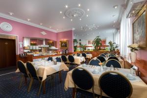 comedor con mesas, sillas y paredes rosas en Hotel ATLANTA, en Darmstadt
