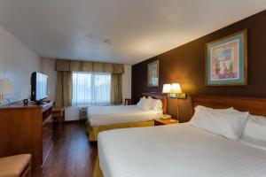 a hotel room with two beds and a television at Vagabond Inn Executive in Green Valley