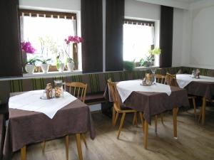 a dining room with tables and chairs and windows at Haus Felsneck in Sölden